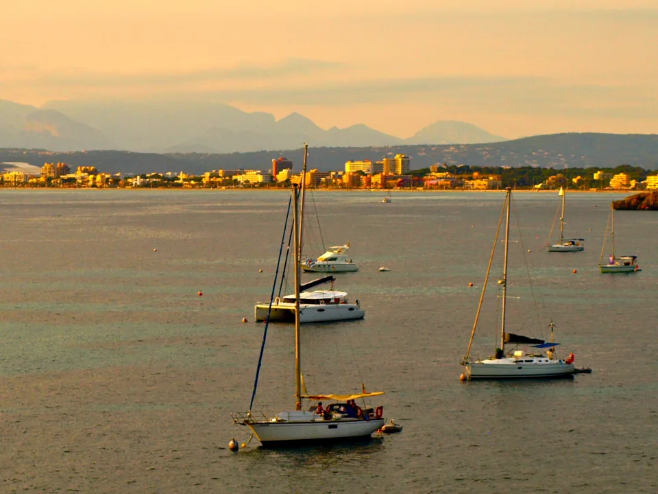Yachts and a catamaran anchored off El Arenal in the Bay of Palma.