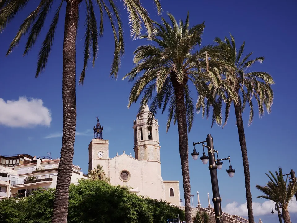 Palm trees and the church on the seafront in Sitges.