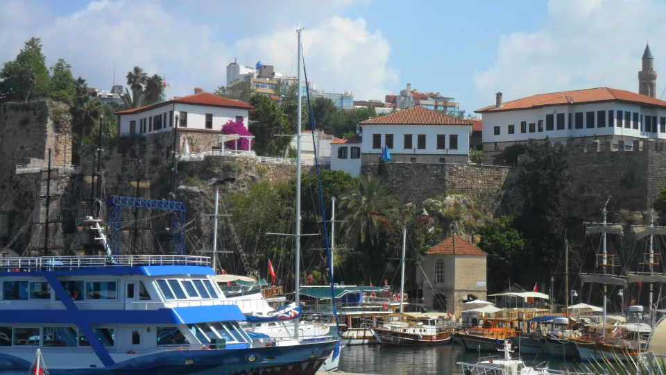 Regional Antalya city context: moored boats beneath the cliffs and buildings of Kaleiçi harbour.