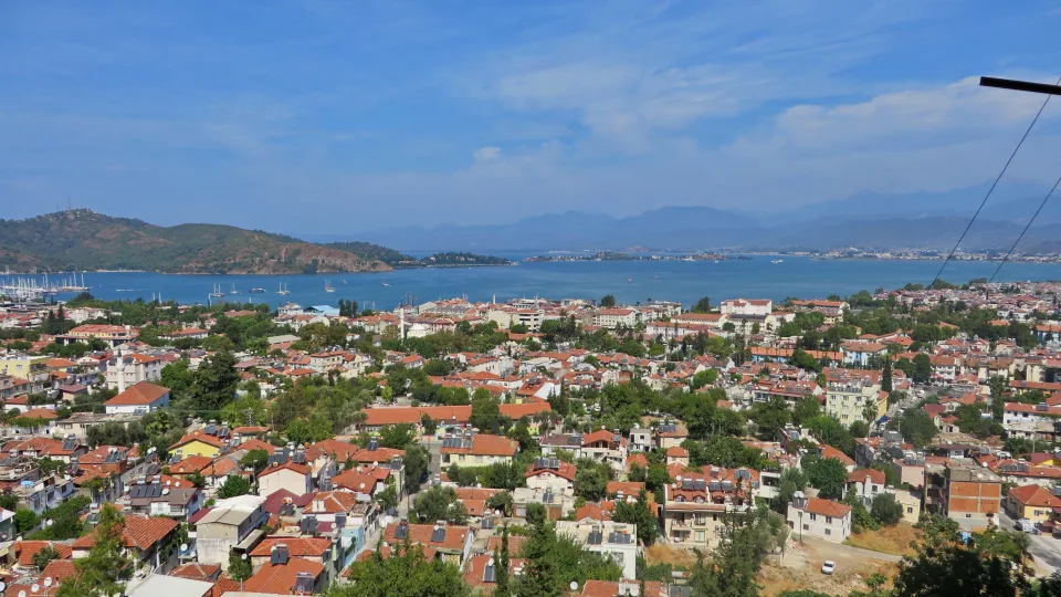 Fethiye rooftops, coastal hills and the blue water of Fethiye Gulf.