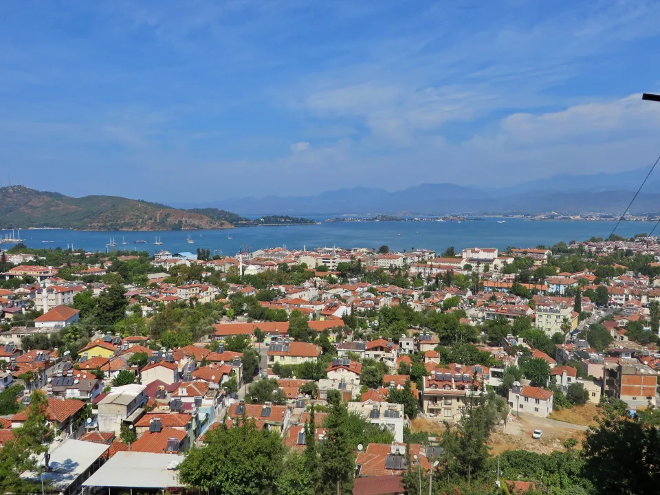 Fethiye rooftops, coastal hills and the blue water of Fethiye Gulf.