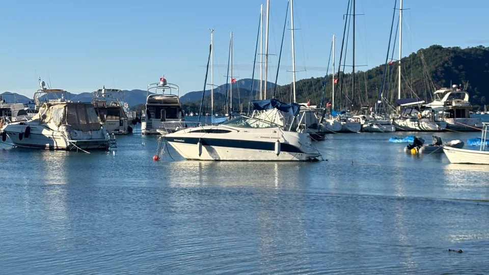 Sailing yachts and masts beside the Göcek waterfront.