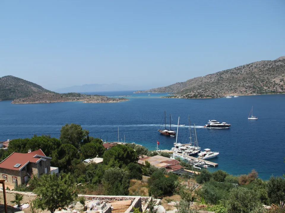 Sailing boats and catamarans on the blue water beside the Bozburun coast in Turkey.