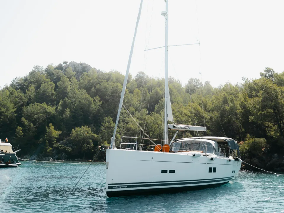A white monohull sailing yacht beside the Selimiye coast in Turkey.