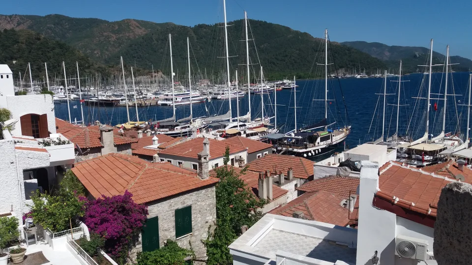 Yachts and masts behind waterside houses at the Marmaris marina.