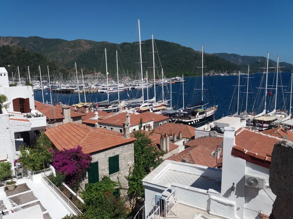Yachts and masts behind waterside houses at the Marmaris marina.